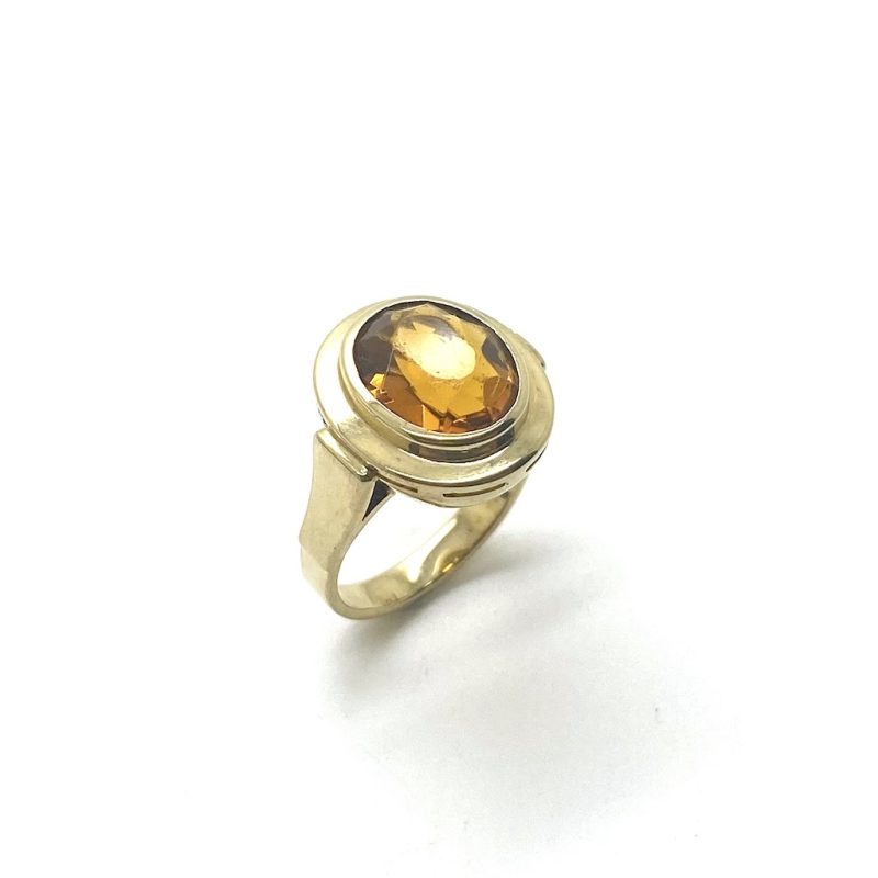 Grote gouden ring met oranje zirkonia.