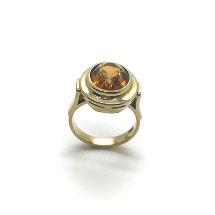 Gouden ring met oranje zirkonia steen.
