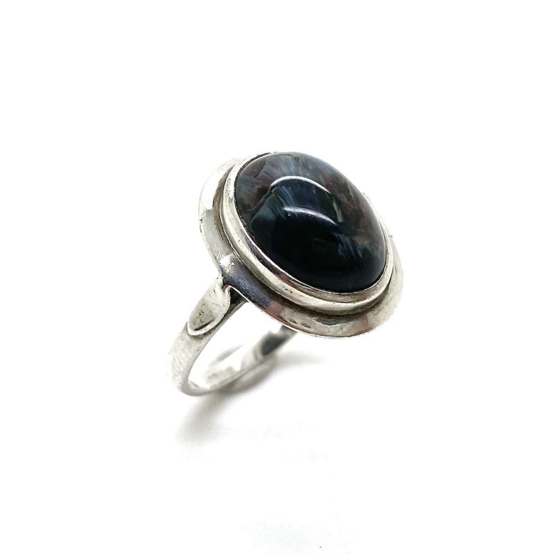 Zilveren ring met ovaal geslepen edelsteen met donkere tinten als donkerblauw, donkerrood en donkergroen.